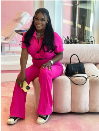 Bianca Simmons seated in her salon wearing pink