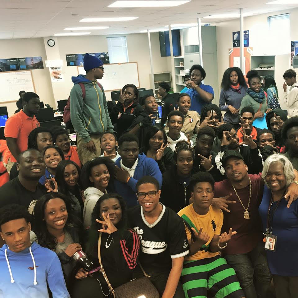 Young people and community members gathered together in a classroom